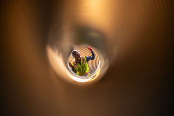 worker inspecting pipe interior